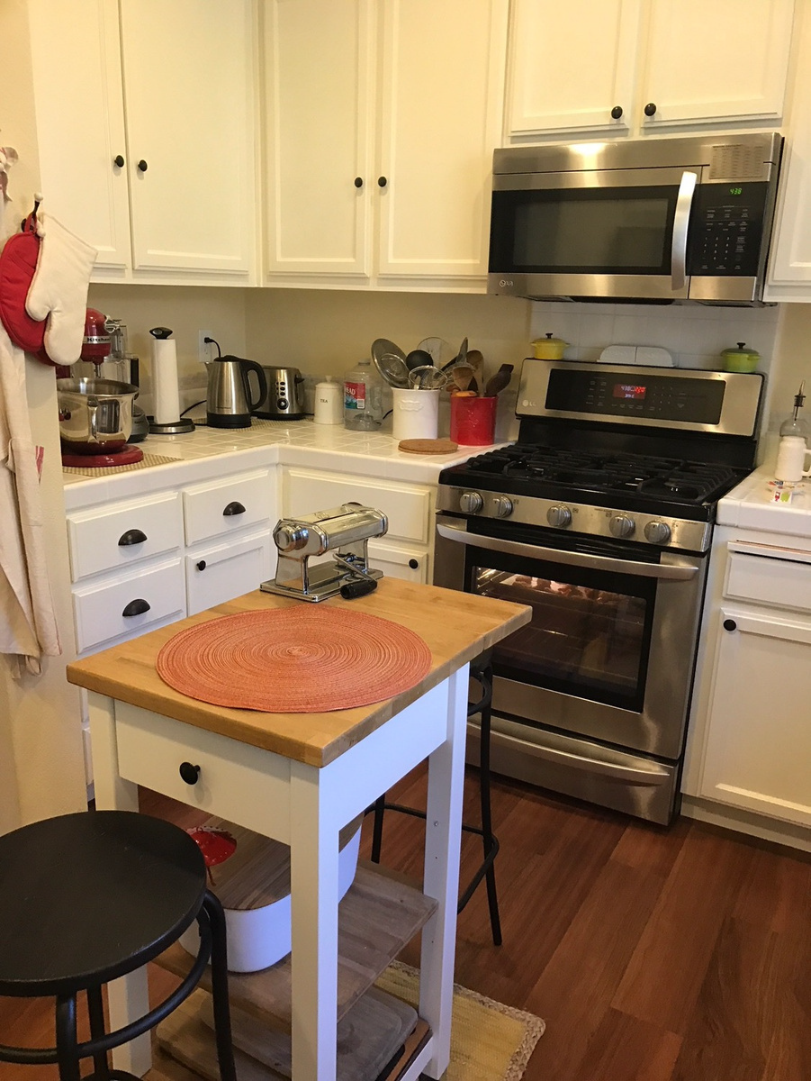 A kitchen with a stove , microwave and a table