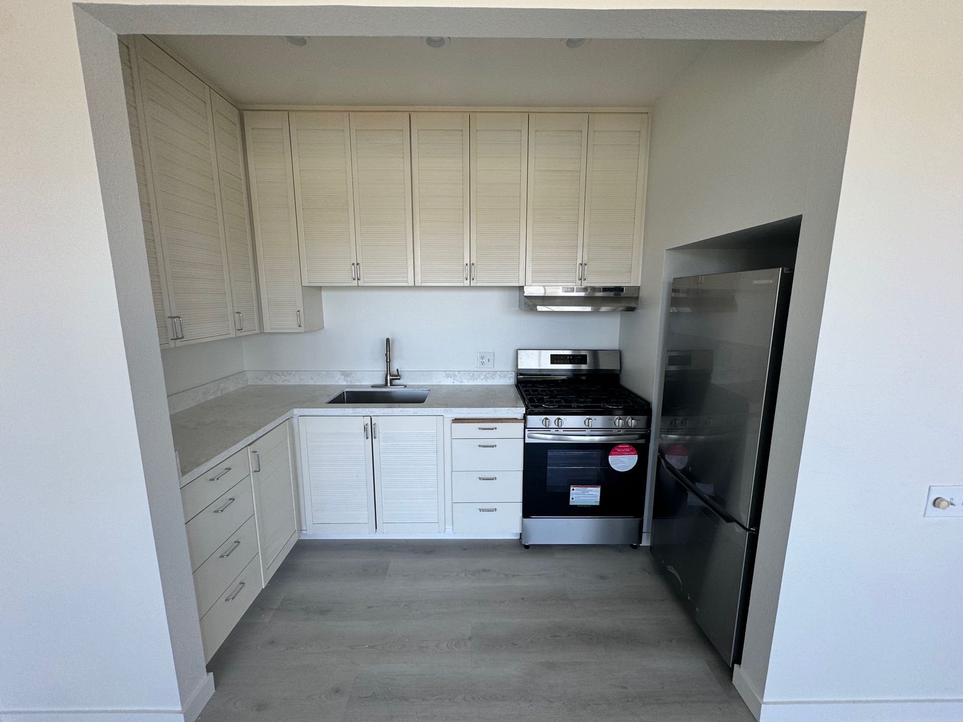 A kitchen with stainless steel appliances and white cabinets