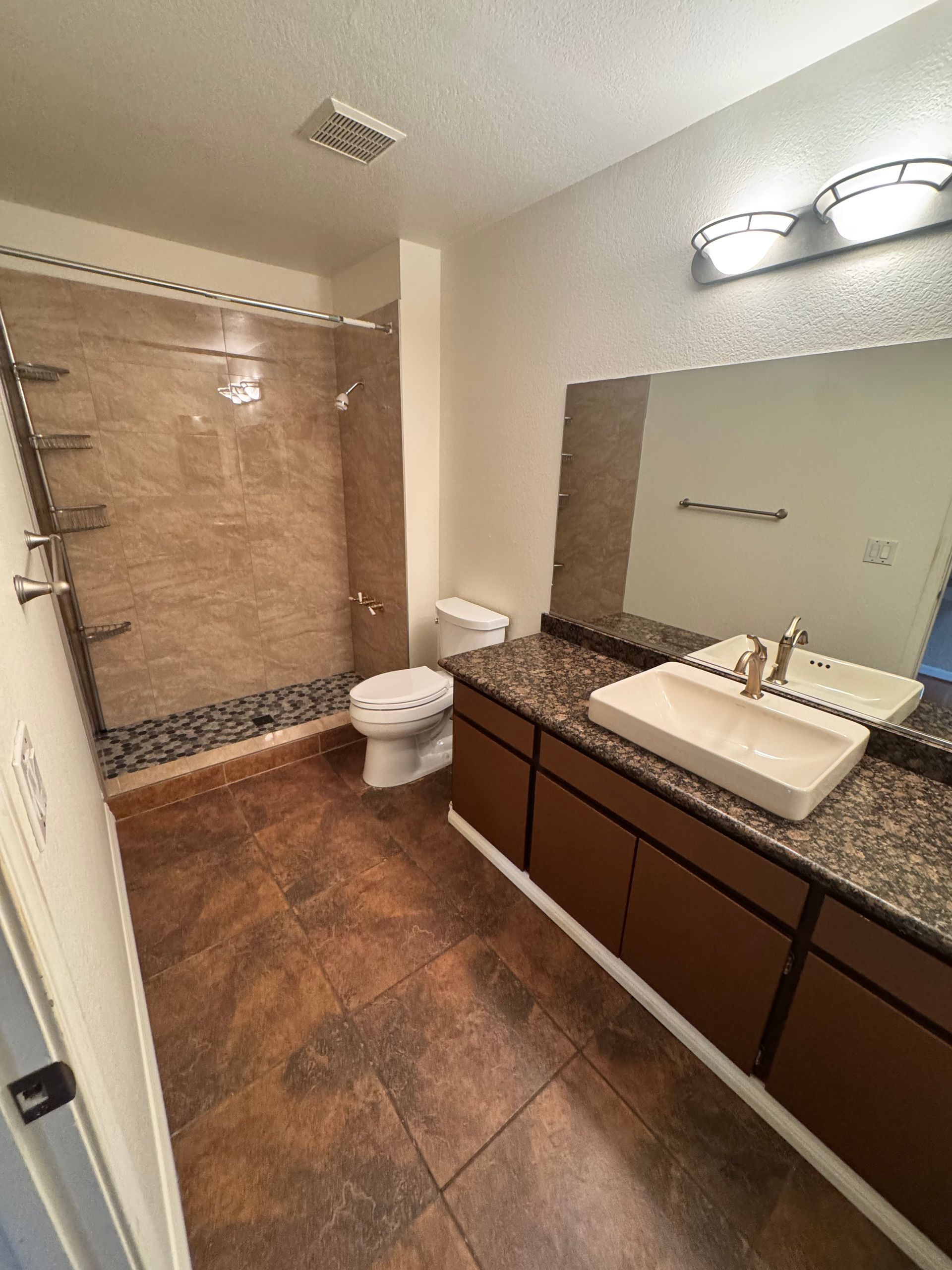 A bathroom with a toilet , sink , and shower.