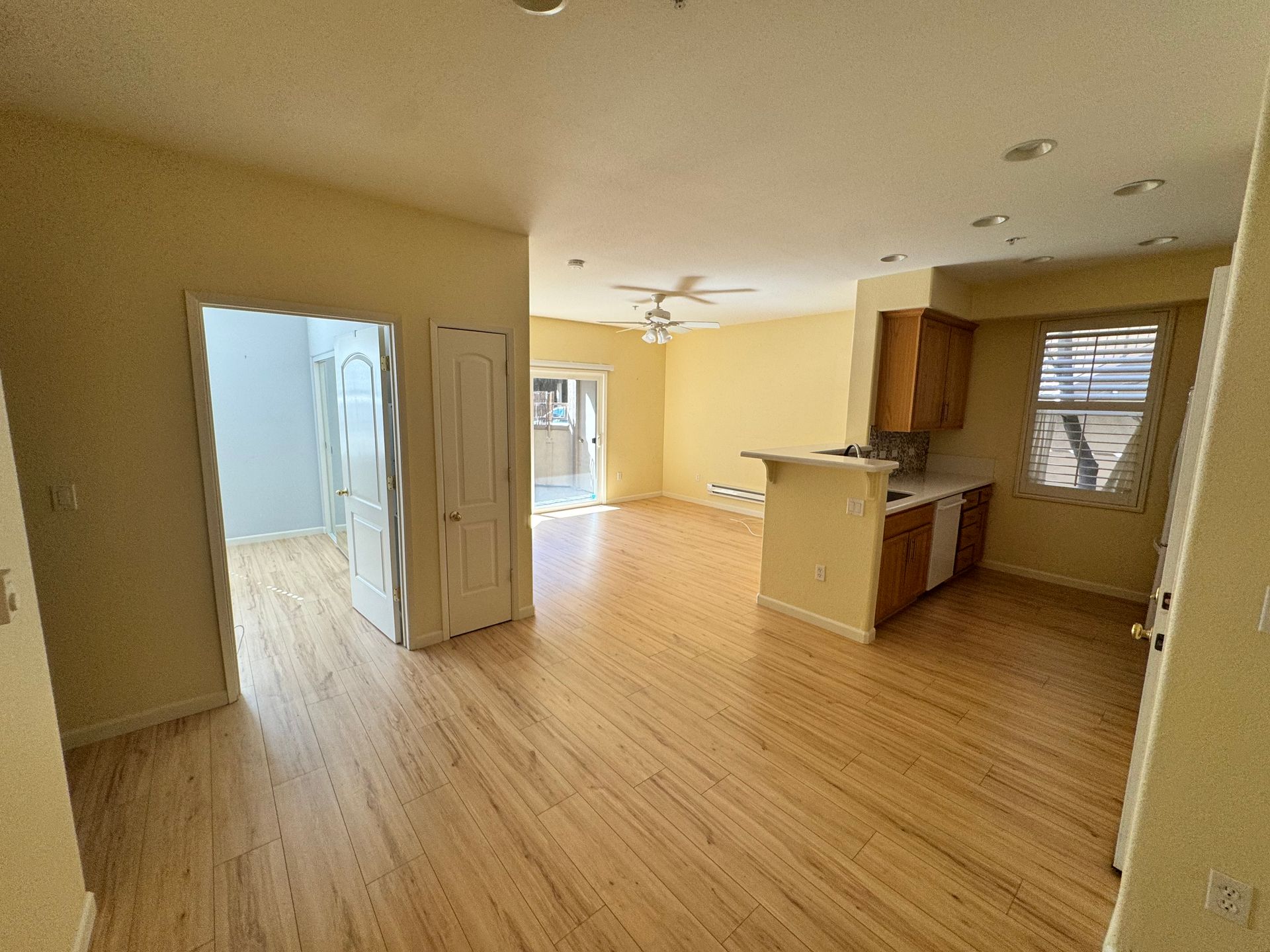 An empty room with hardwood floors and a ceiling fan
