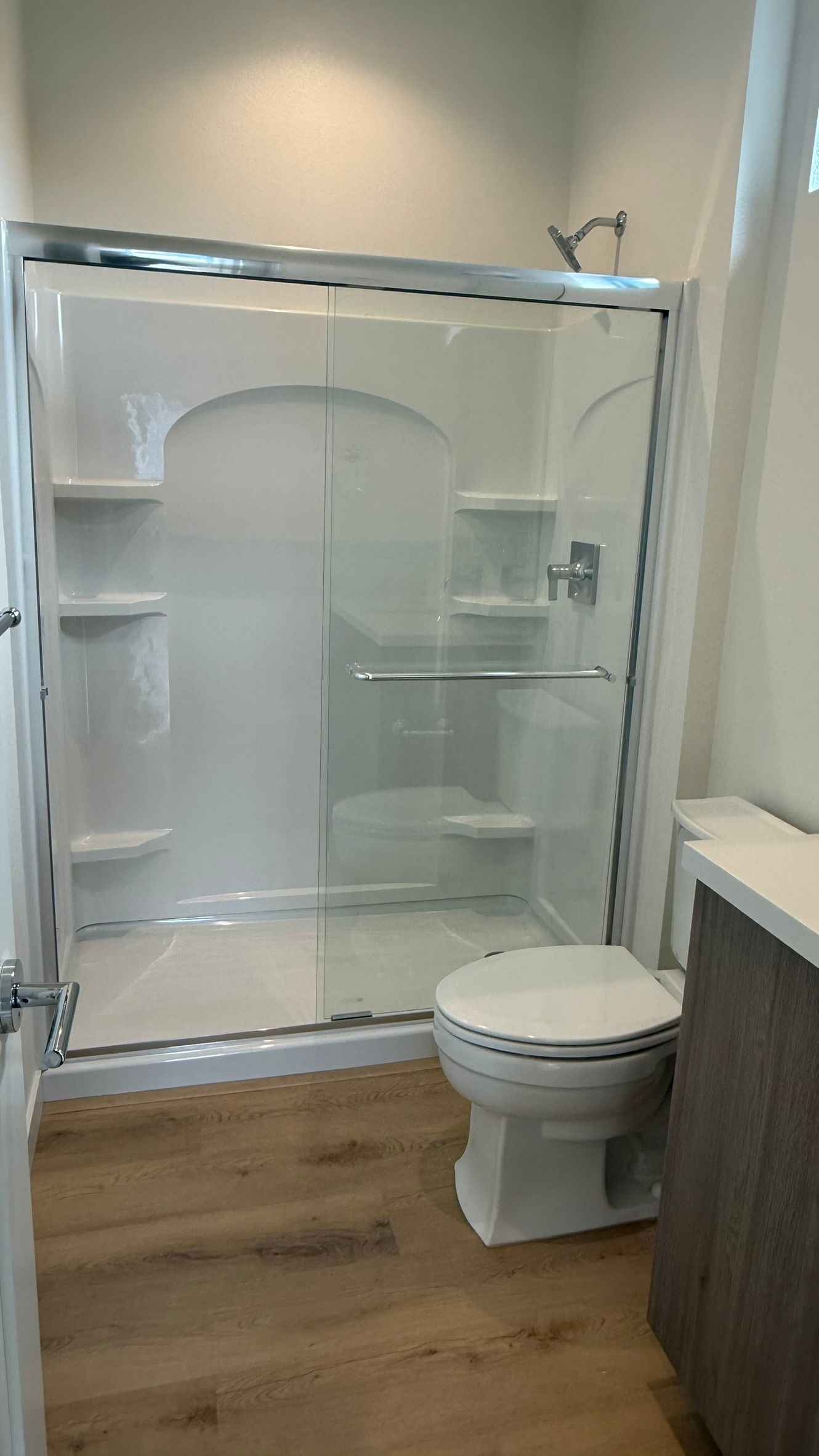 Empty beige bedroom with white closet doors, open door, and carpeted floor