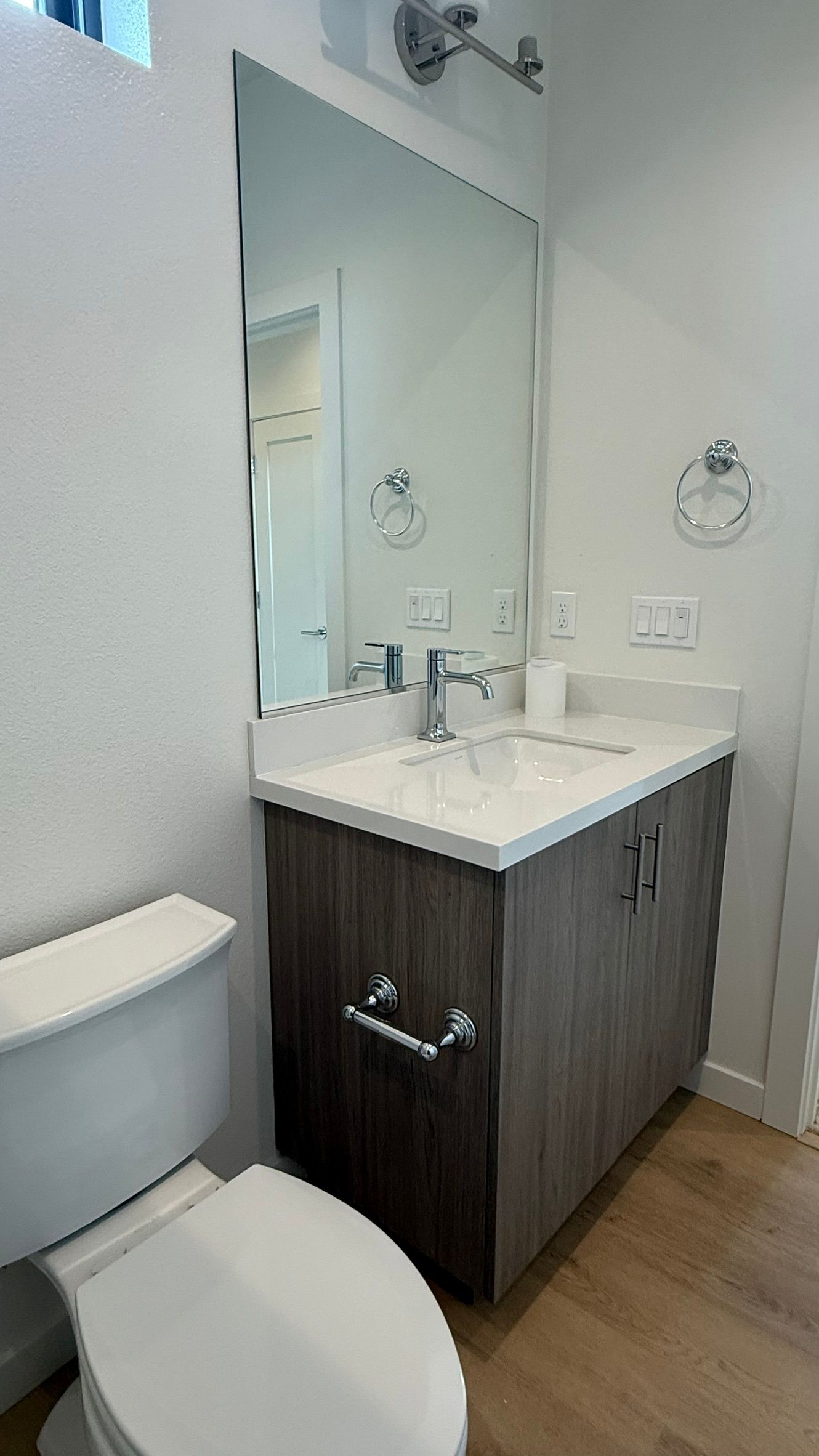 Modern bathroom vanity with sink, mirror, toilet, and wood cabinet cabinetry