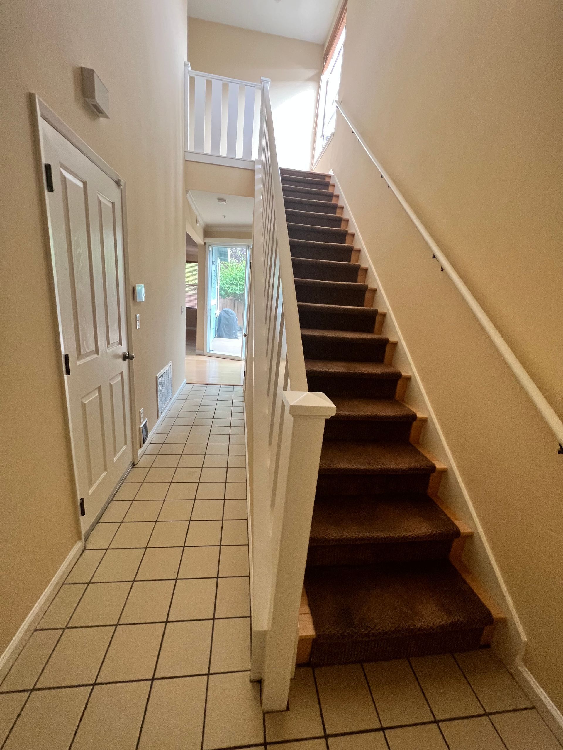 A hallway with stairs leading up to the second floor.
