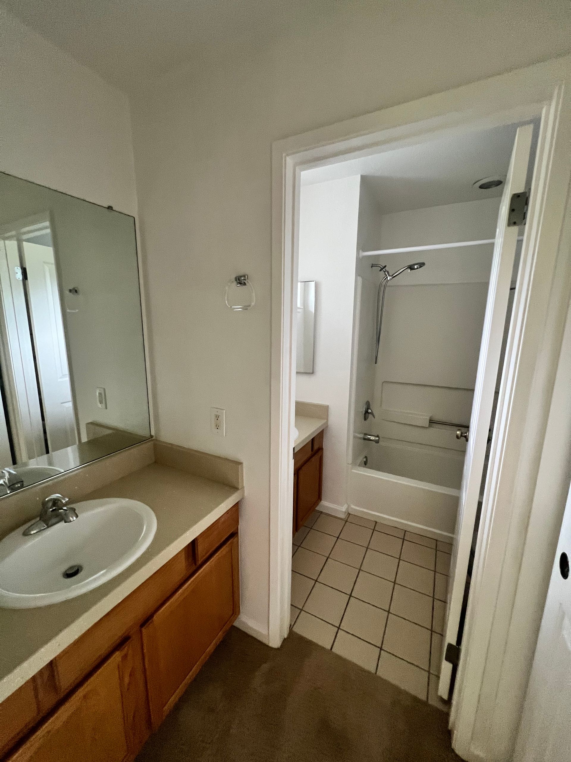 A bathroom with a sink , mirror and bathtub.