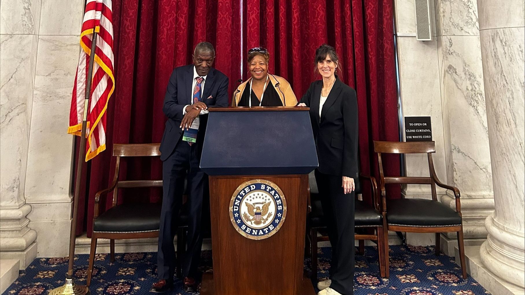 A group of people standing around a podium with the seal of the united states on it