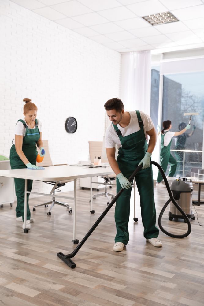 A Man is Using a Vacuum Cleaner to Clean an Office — Cleaners in Tamworth, NSW 