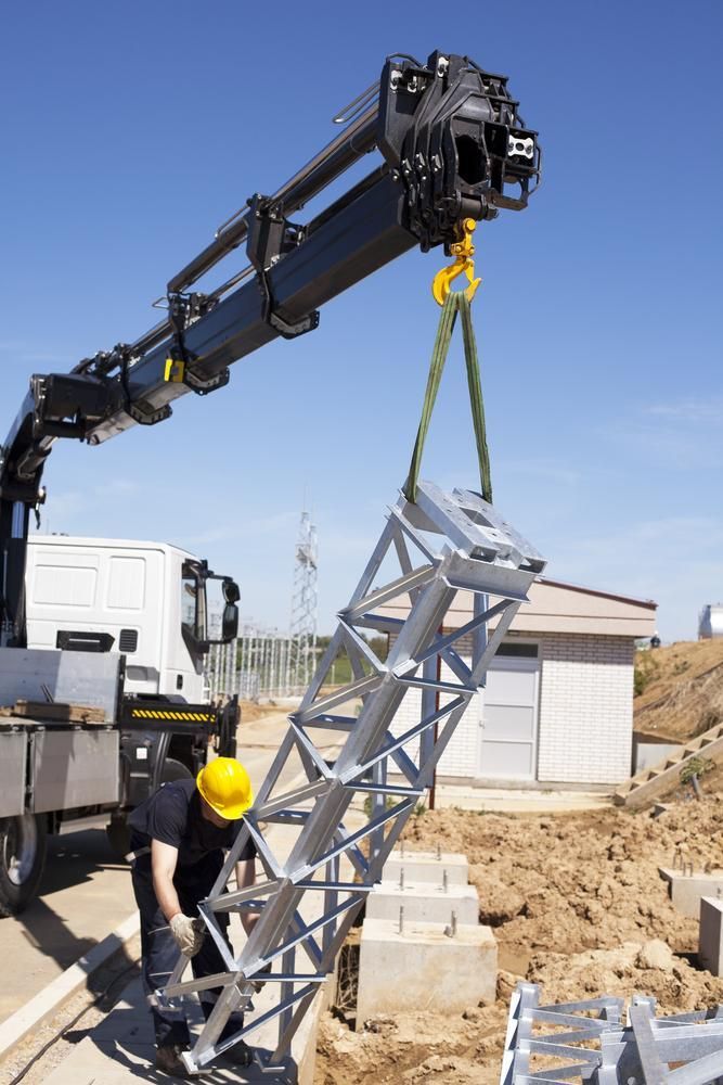 A Man Is Lifting a Metal Structure with A Crane — AMAC Cranes in Coolum Beach, QLD