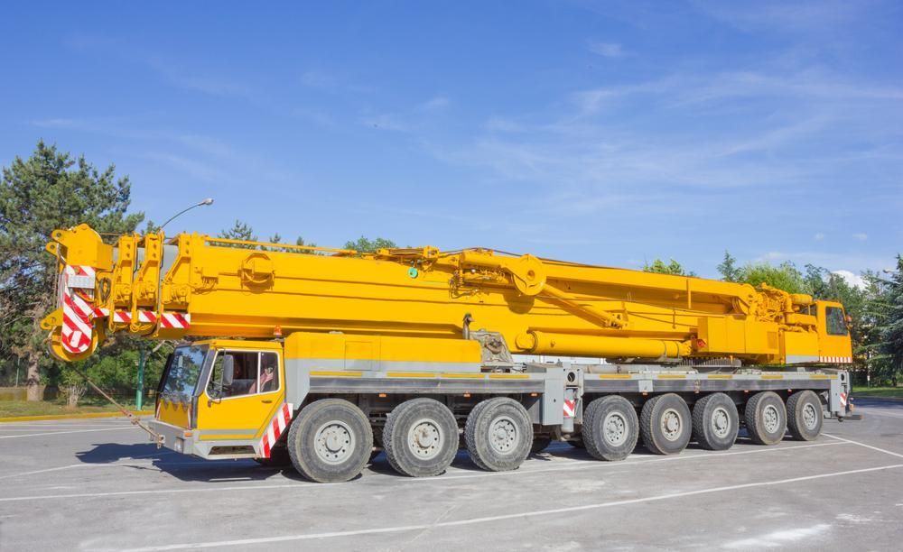 A Large Yellow Crane Is Parked in A Parking Lot — AMAC Cranes in Coolum Beach, QLD