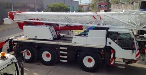 A White Truck with A Red Crane on Top of It Is Parked on The Side of The Road — AMAC Cranes in Coolum Beach, QLD