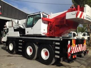 A Large Red and White Crane Is Parked in Front of A Building — AMAC Cranes in Coolum Beach, QLD