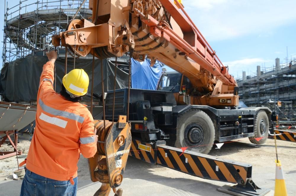 A Construction Worker Is Working on A Crane at A Construction Site — AMAC Cranes in Coolum Beach, QLD