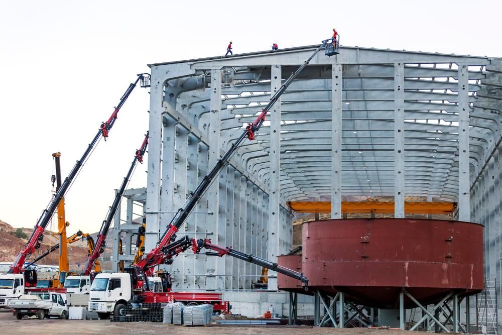 A Large Building Under Construction with A Lot of Cranes and Trucks — AMAC Cranes in Coolum Beach, QLD