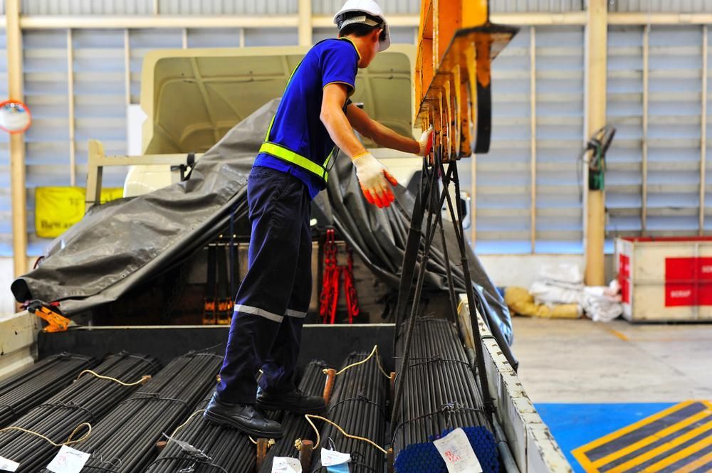 A Man Is Standing on The Back of A Truck — AMAC Cranes in North Lakes, QLD