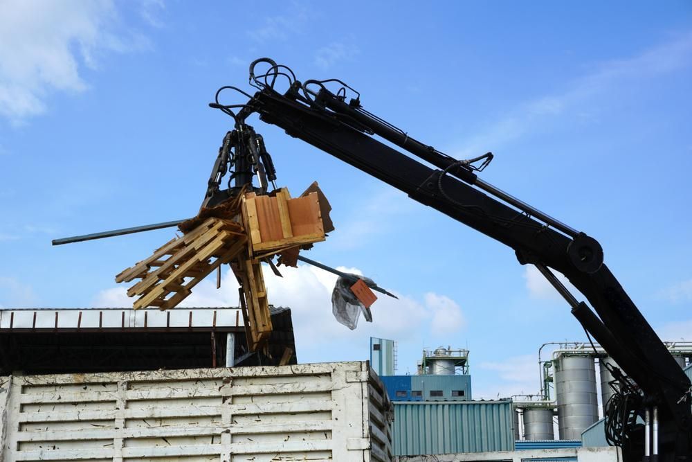 A Crane Is Lifting a Piece of Wood from A Truck — AMAC Cranes in Coolum Beach, QLD