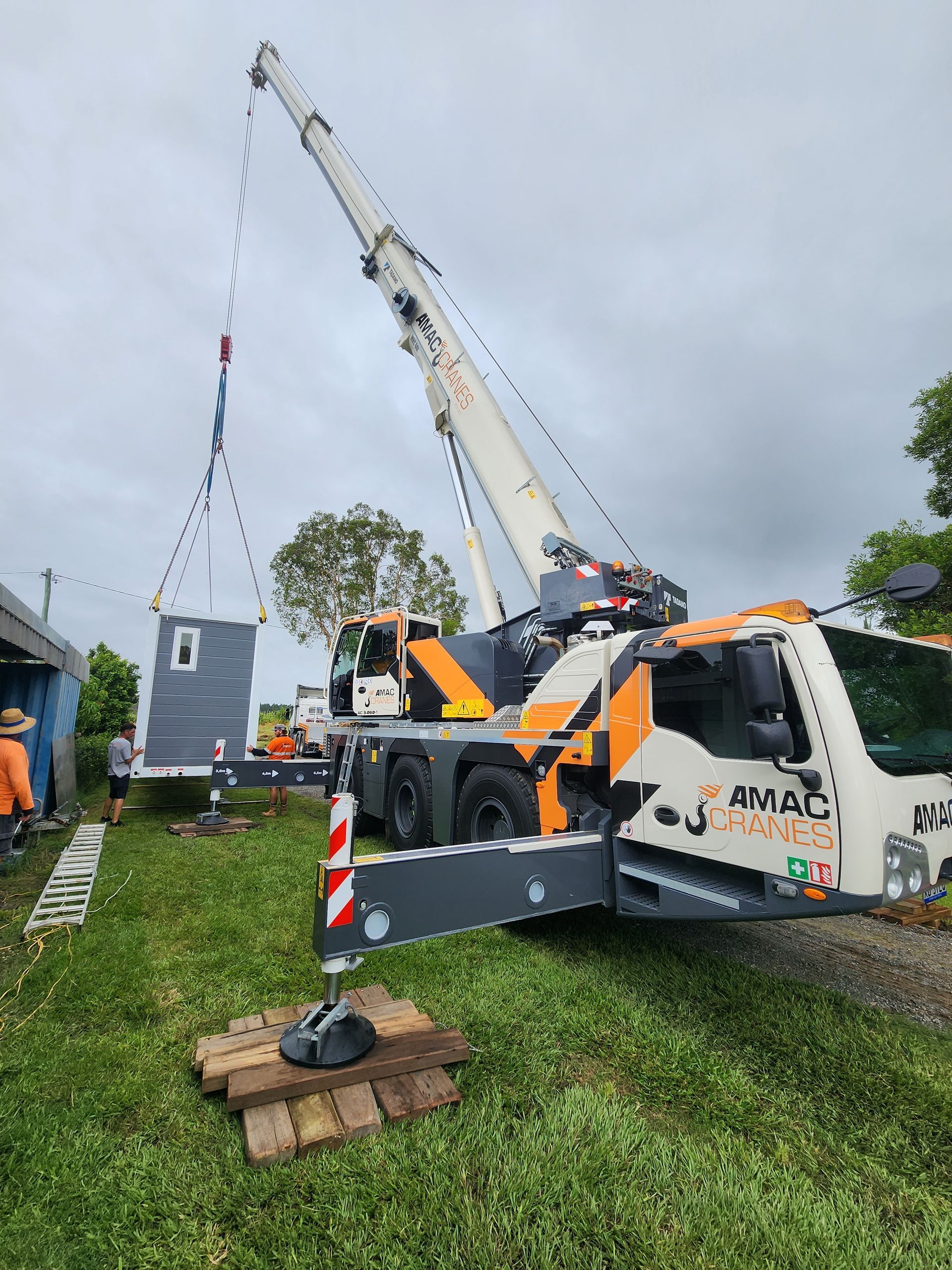 A White and Orange Crane Lifting An Object — AMAC Cranes in Coolum Beach, QLD