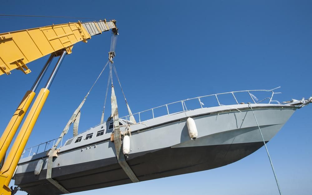 A Boat Is Being Lifted by A Large Yellow Crane — AMAC Cranes in Coolum Beach, QLD