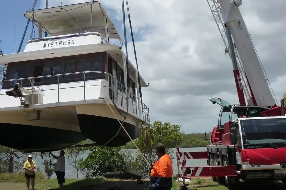 A Boat Is Being Lifted Into the Water by A Crane — AMAC Cranes in North Lakes, QLD