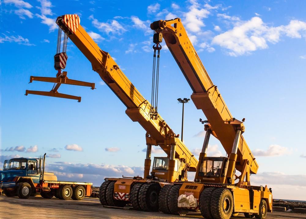 Two Yellow Cranes Are Sitting Next to Each Other in A Parking Lot — AMAC Cranes in Coolum Beach, QLD