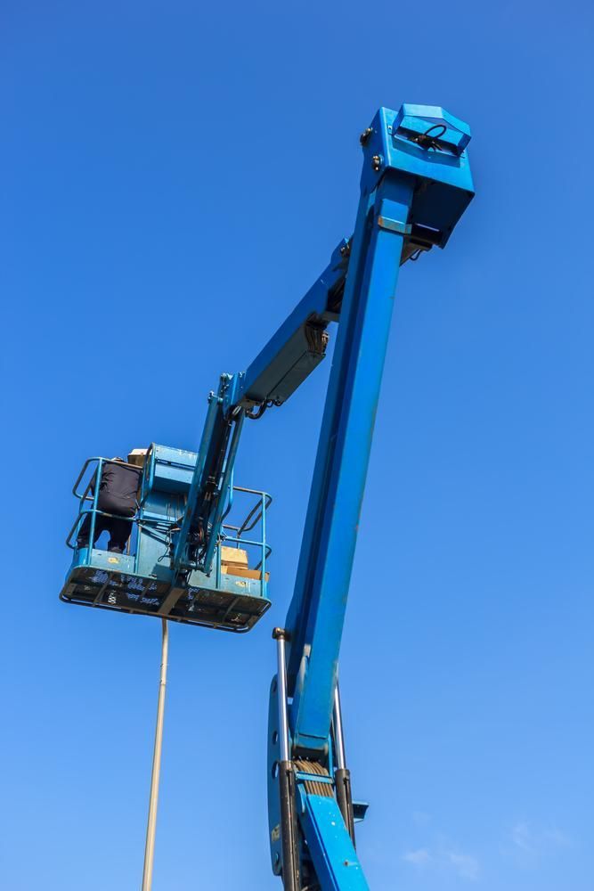 A Man Is Working on A Crane with A Blue Sky in The Background — AMAC Cranes in Coolum Beach, QLD