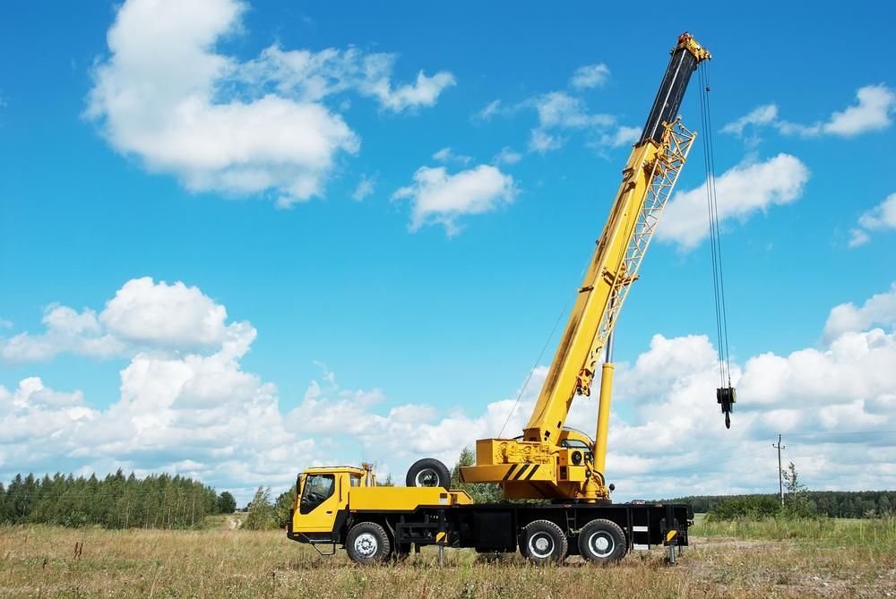 A Yellow Crane Is Sitting on Top of A Truck in A Field — AMAC Cranes in Coolum Beach, QLD