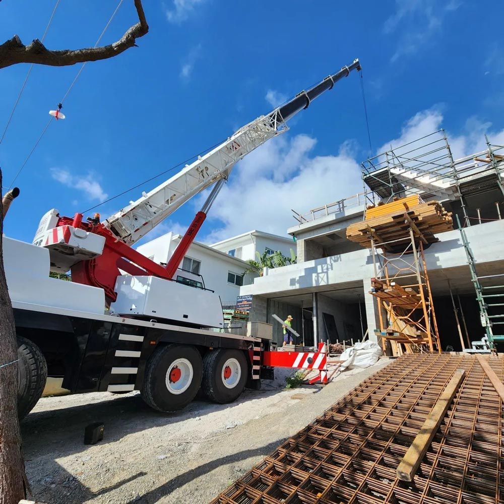 A Large Crane Is Parked in Front of A Building Under Construction — AMAC Cranes in Coolum Beach, QLD A Large Crane Is Parked in Front of A Building Under Construction — AMAC Cranes in Coolum Beach, QLD