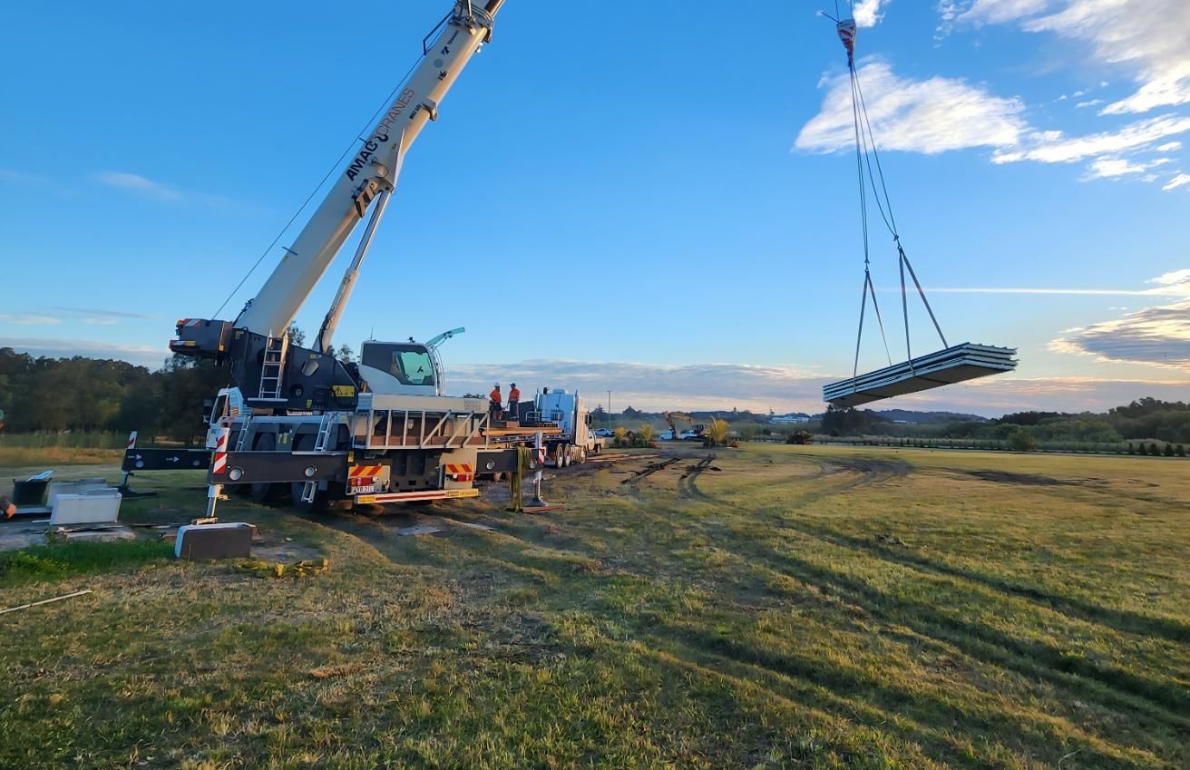 A Man Is Driving a Truck with A Crane Attached to It — AMAC Cranes in Caboolture, QLD 