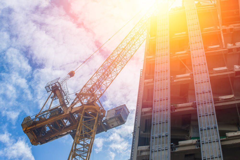 A Construction Crane and A Building Under Construction — AMAC Cranes in Coolum Beach, QLD A Construction Crane and A Building Under Construction — AMAC Cranes in Coolum Beach, QLD