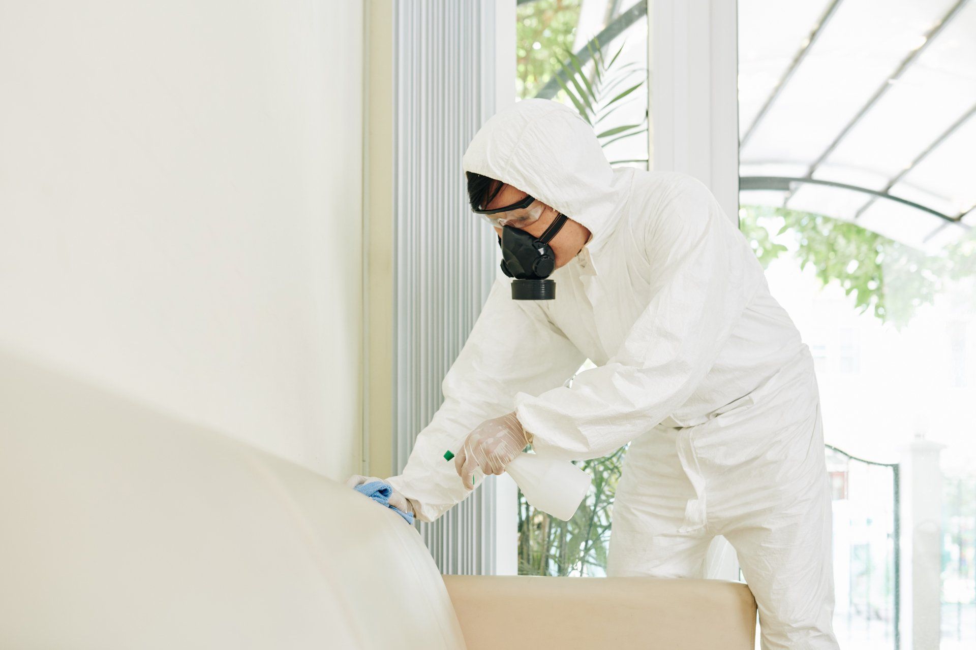 Worker cleaning furniture in home
