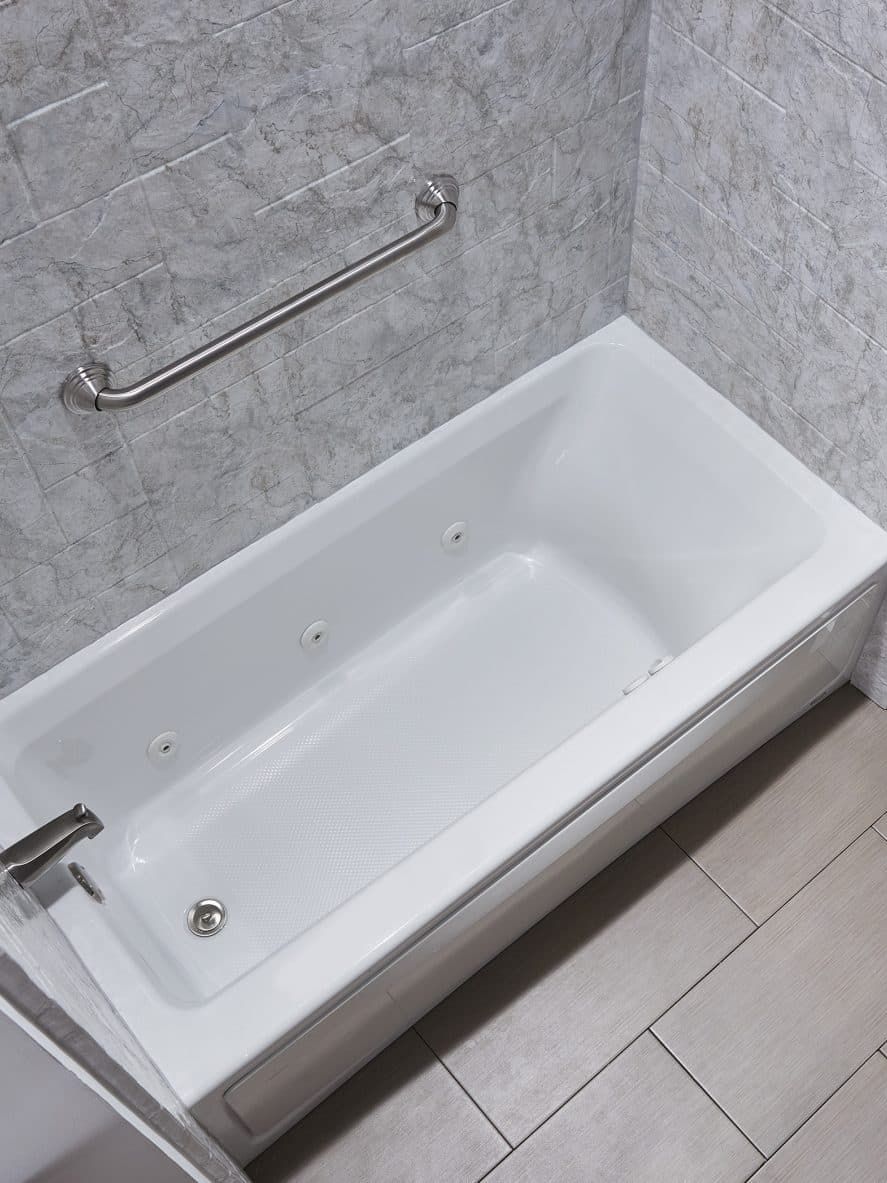 A white bathtub is sitting in a bathroom next to a shower.