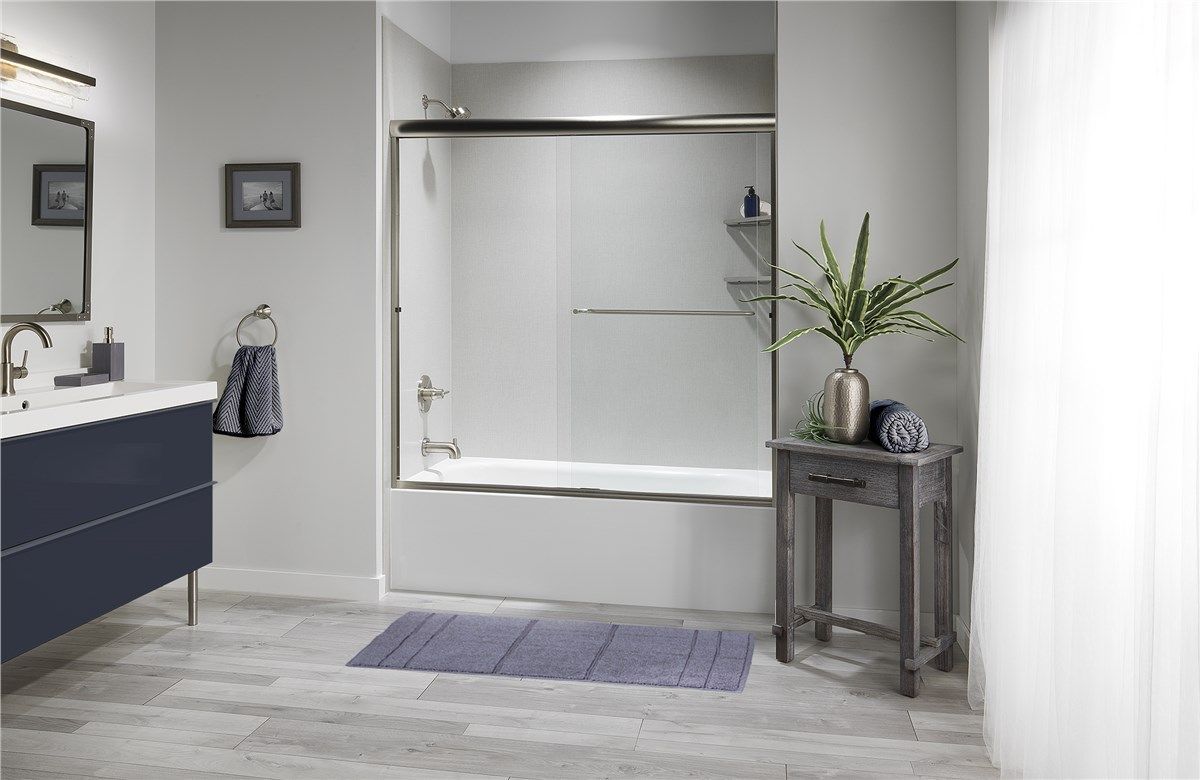 A bathroom with a bathtub , sink and mirror.