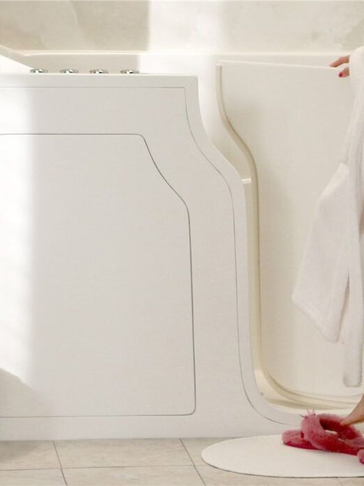 A woman in a bathrobe is standing in a walk in tub