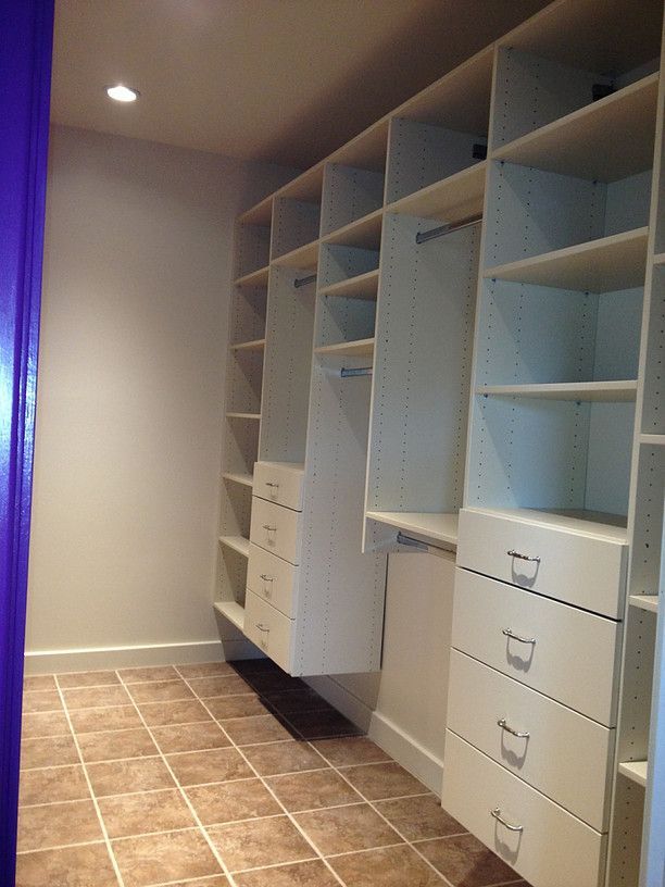Walk-in closet with gray shelving and drawers, tiled floor, and purple wall trim.