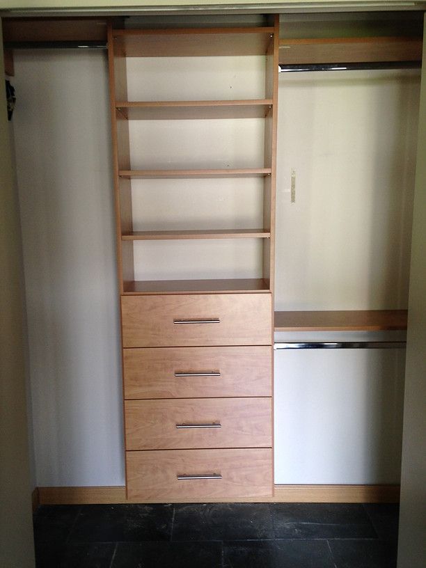 Built-in closet with shelves, drawers, hanging rods, and sliding doors.