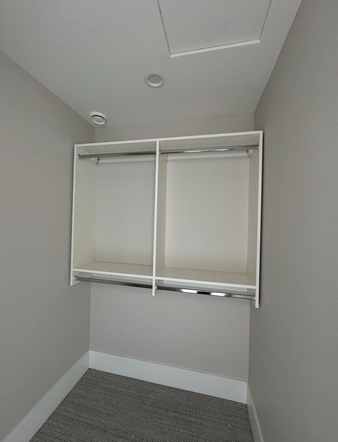 Empty closet with white wire shelving and gray carpet in a small alcove