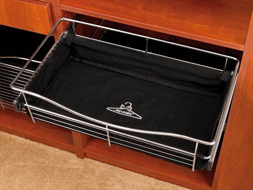 Open dresser drawer with a black wire basket organizer on a carpeted floor.