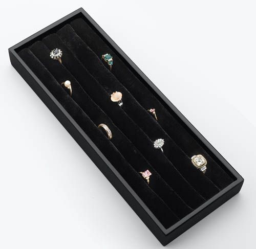 Black velvet jewelry tray with several rings arranged in rows.