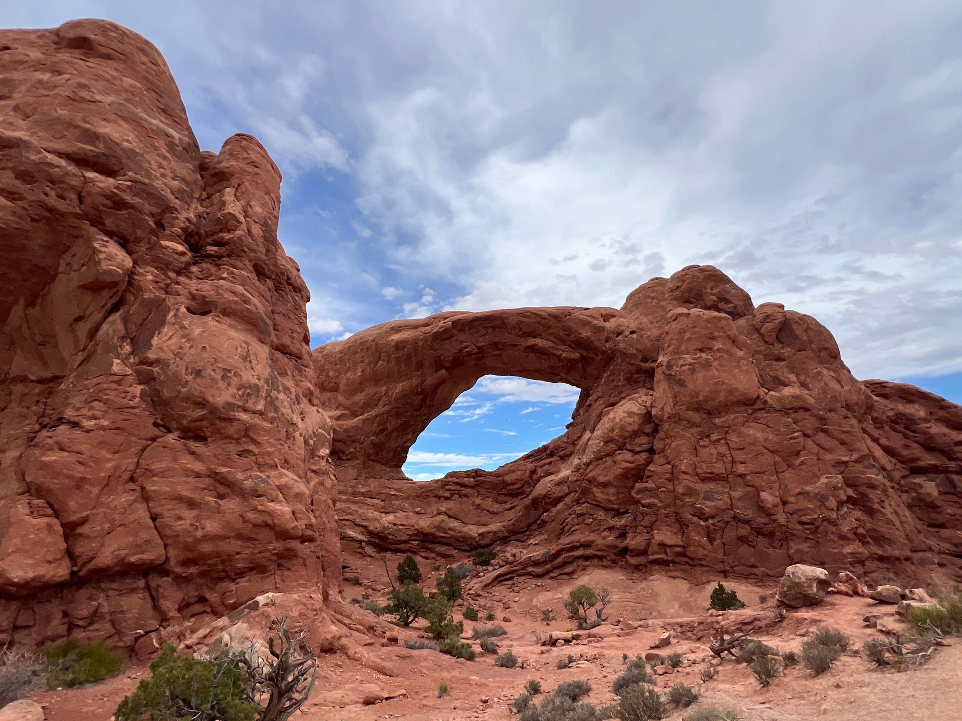 Arches National Park: Turret Arch, a large natural sandstone arch with blue sky visible through the opening.