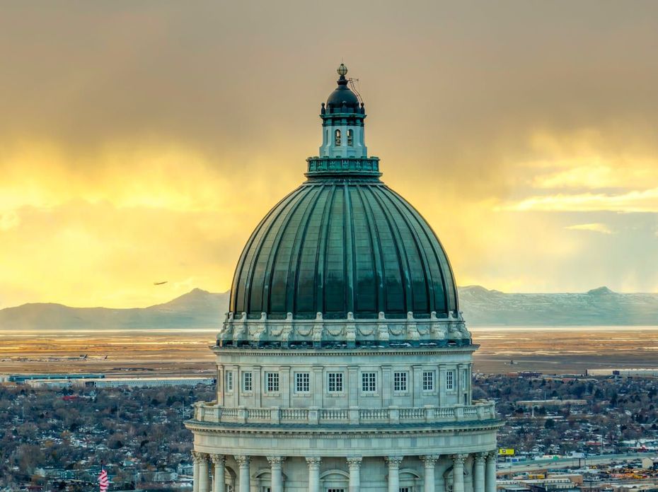 Dome of the Utah State Capitol Building against a golden, overcast sky.