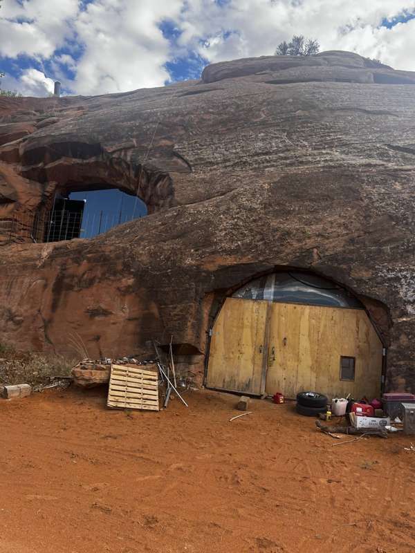 Arched wooden doors and windows set into the red sandstone of the Rock House