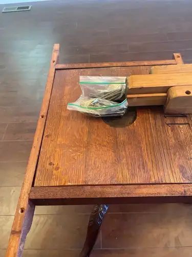 Wooden table with two bags of items on top.