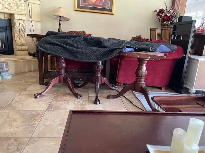 Two dark wood tables covered with a dark blue blanket in a living room.