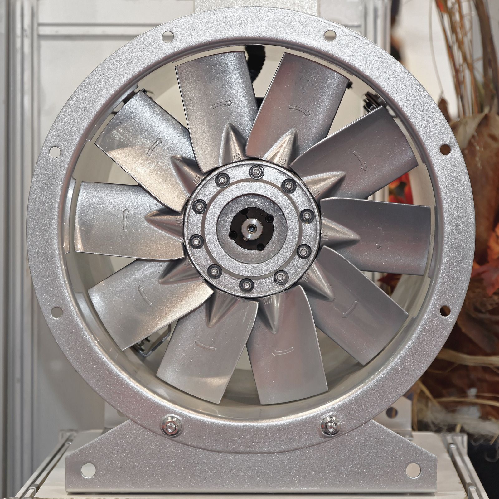 Silver industrial fan with multiple blades mounted in a metal frame on a workbench