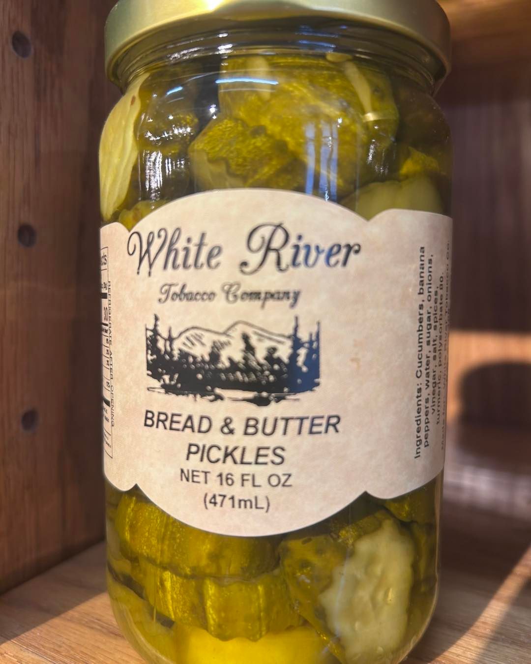 Jars of pickled cucumbers with dill, garlic, salt, and fresh cucumbers on a rustic wooden table