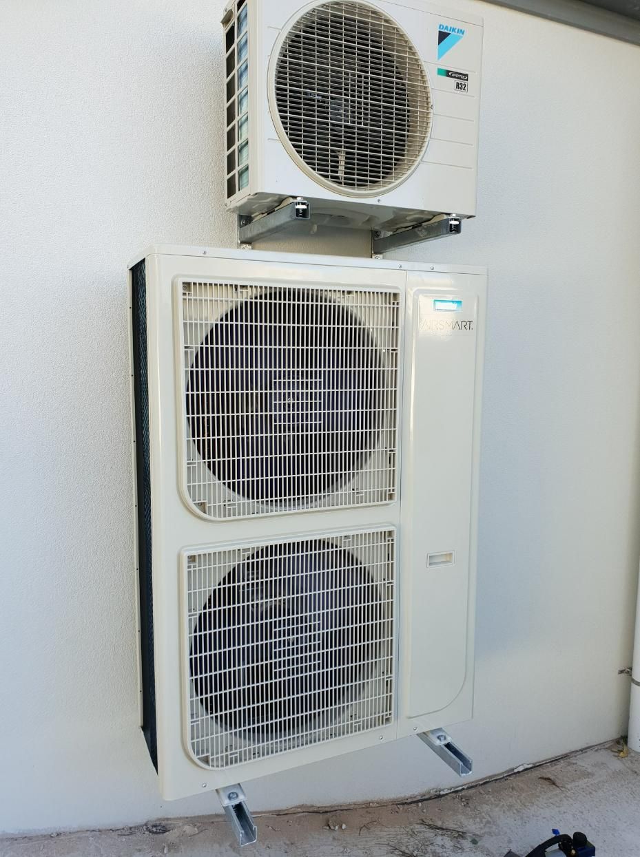 Two Air Conditioners Are Mounted On A White Wall — Jervis Bay Airconditioning In Sanctuary Point, NSW