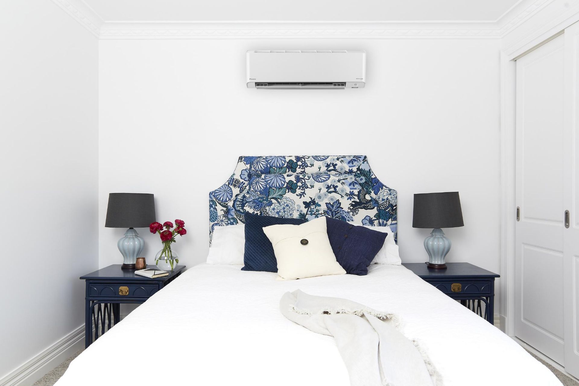 A Bedroom With A Bed , Nightstands, Lamps, And Air Conditioner — Jervis Bay Airconditioning In Huskisson, NSW