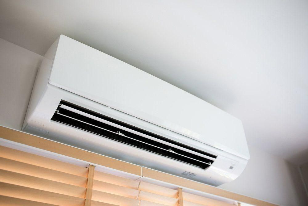 A White Air Conditioner Is Hanging From The Ceiling In A Room — Jervis Bay Airconditioning In Huskisson, NSW