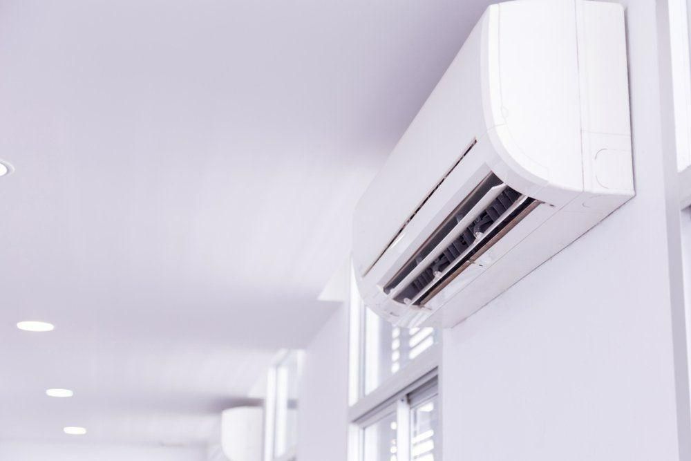 A White Air Conditioner Is Hanging On A White Wall In A Hallway — Jervis Bay Airconditioning In Huskisson, NSW