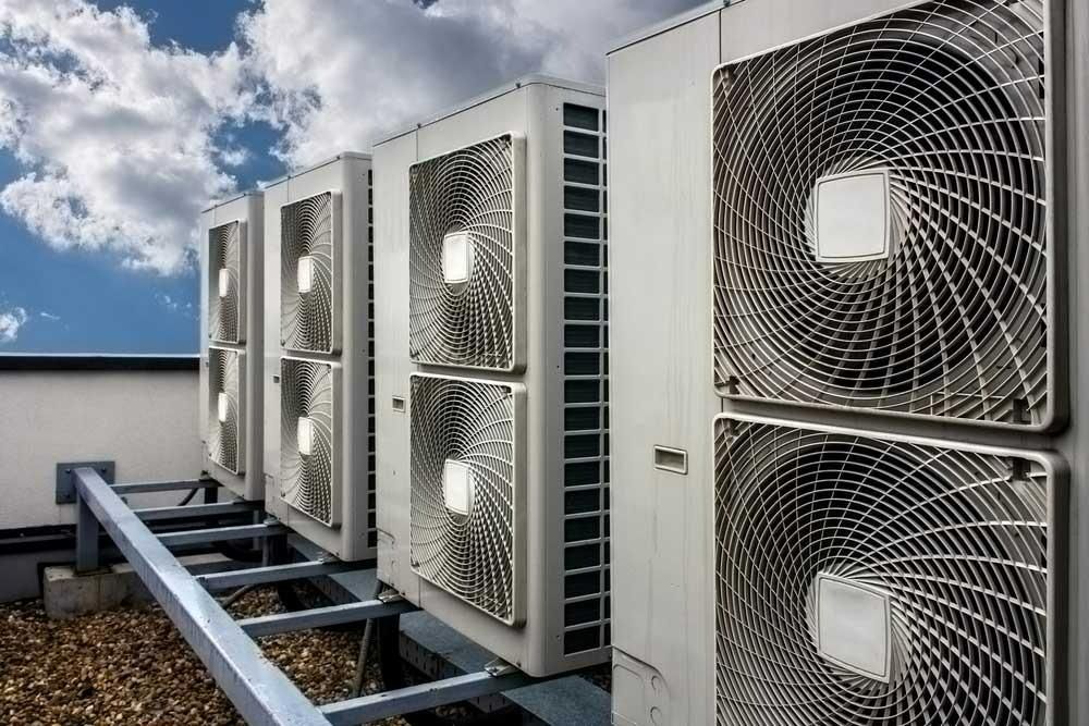 A Row Of Air Conditioners Are Sitting On Top Of A Building — Jervis Bay Airconditioning In Kiama, NSW