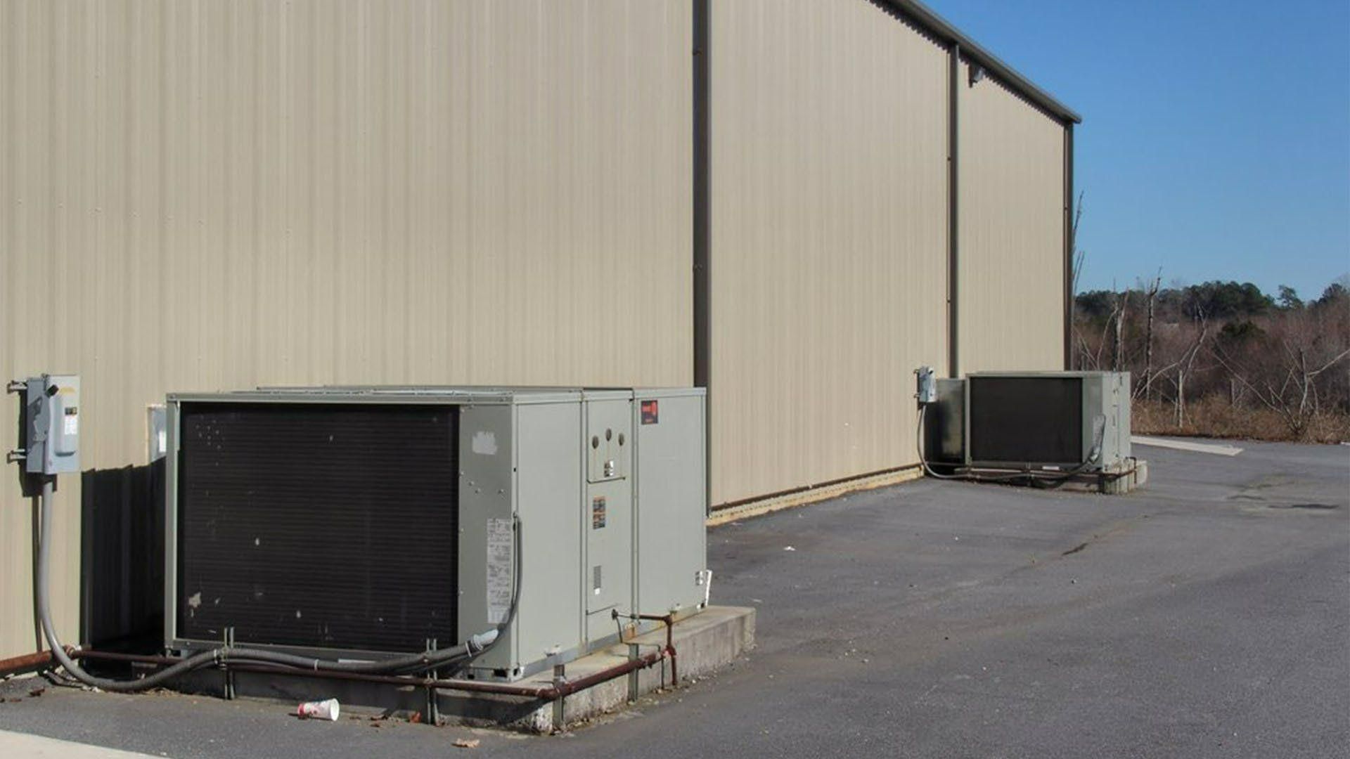 Two Air Conditioners Are Sitting Outside Of A Building — Jervis Bay Airconditioning In Sussex Inlet, NSW
