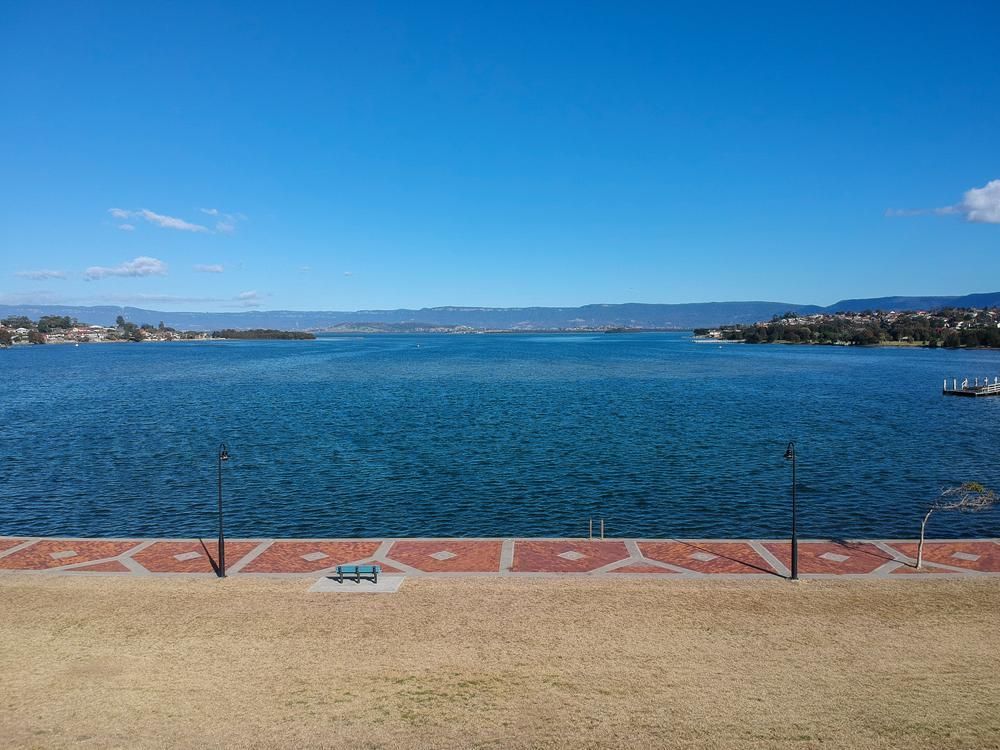 An Aerial View Of A Large Body Of Water With Mountains In The Background — Jervis Bay Airconditioning In Kemblawarra, NSW